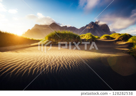 Beautiful view of the yellow hills glowing by sunlight. Location place Stokksnes cape, Vestrahorn, Iceland, Europe. 128282538