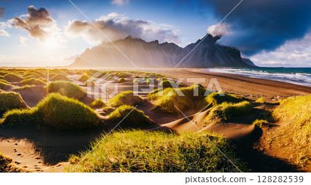 Beautiful view of the yellow hills glowing by sunlight. Location place Stokksnes cape, Vestrahorn, Iceland, Europe. 128282539