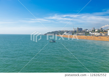 Wide Coastal View of Folkestone Beach, Turquoise English Channel and Fishing Boat, Kent UK Wide Coastal View of Folkestone Beach, Turquoise English Channel and Fishing Boat, Kent UK 128282552