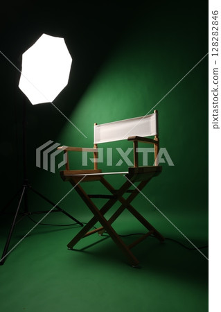 Chair of Film Director. Directors chair in green screen studio setup with softbox lighting. Ideal for filmmaking video production photo interviews and creative content with green chroma key background Chair of Film Director. Directors chair in green screen studio setup with softbox lighting. Ideal for filmmaking video production photo interviews and creative content with green chroma key background 128282846