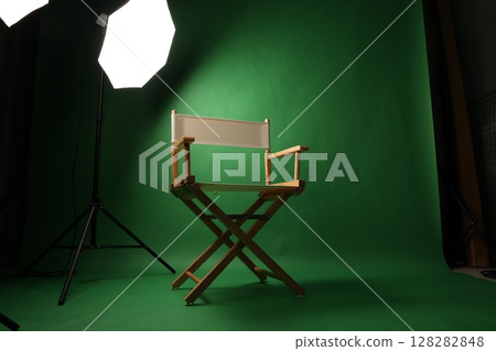 Chair of Film Director. Directors chair in green screen studio setup with softbox lighting. Ideal for filmmaking video production photo interviews and creative content with green chroma key background 128282848