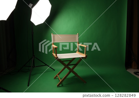 Chair of Film Director. Directors chair in green screen studio setup with softbox lighting. Ideal for filmmaking video production photo interviews and creative content with green chroma key background Chair of Film Director. Directors chair in green screen studio setup with softbox lighting. Ideal for filmmaking video production photo interviews and creative content with green chroma key background 128282849