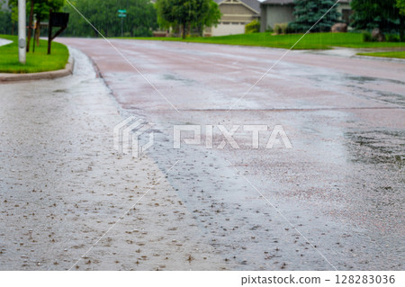 Backed up standing water on a residential street after a rain storm downpour.  128283036