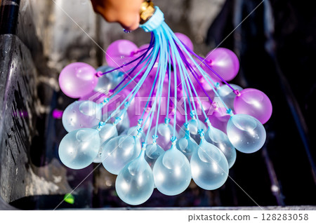 Rapid filling self sealing water balloons being inflated with a hose. 128283058