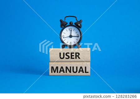 User Manual symbol. Concept words User Manual on wooden blocks. Beautiful blue background with alarm clock. Business and User Manual concept. Copy space. User Manual symbol. Concept words User Manual on wooden blocks. Beautiful blue background with alarm clock. Business and User Manual concept. Copy space. 128283266