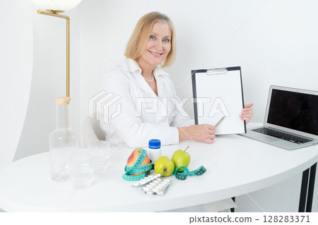 female doctor consulting patient, discussing test result in doctor office. Showing medical report female doctor consulting patient, discussing test result in doctor office. Showing medical report 128283371