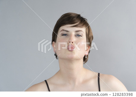 Happy young girl isolated over gray background 128283398