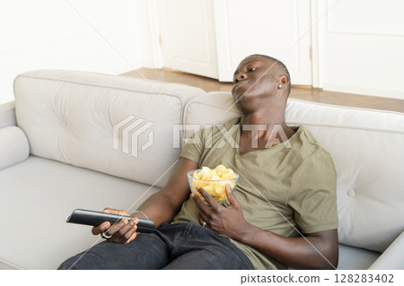 Young man watching TV 128283402