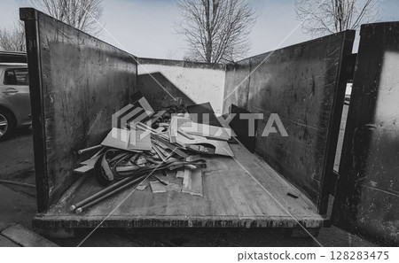 View inside an open dumpster being filled with construction debris. View inside an open dumpster being filled with construction debris. 128283475