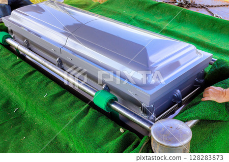 Coffin being handled during funeral preparation somber atmosphere reflects seriousness of occasion. 128283873