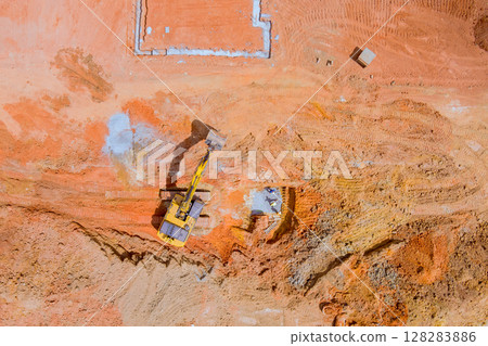 Excavator is digging moving earth on construction site preparing for foundations under works day 128283886