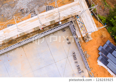 Workers are constructing building foundations with scaffolding materials at construction site in day hours Workers are constructing building foundations with scaffolding materials at construction site in day hours 128283925