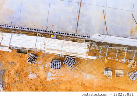 Construction crews are working on building, arranging materials scaffolding in an urban construction site. 128283931
