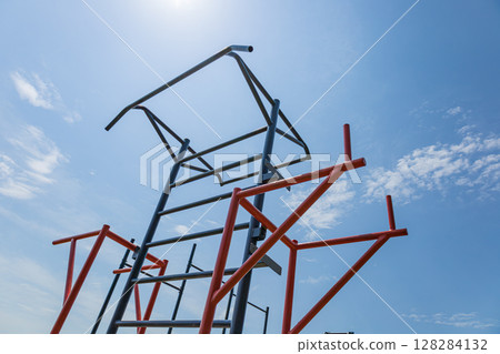 Parallel bars stand tall in an outdoor gym, promoting active lifestyles and strength training under a bright sun 128284132