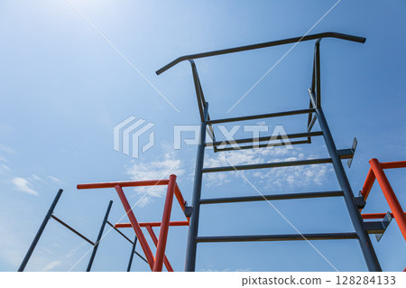 Parallel bars stand tall against a vibrant blue sky, creating a perfect spot for exercise and strength training for athletes and gymnasts 128284133