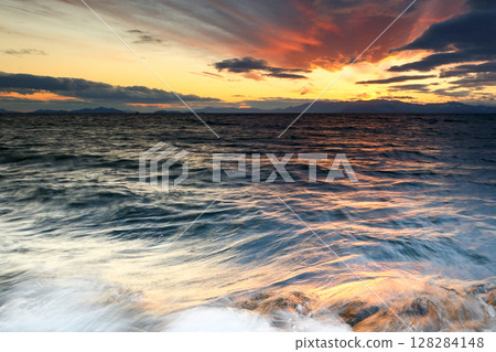 Waves on the lake dyed in the sunset 128284148