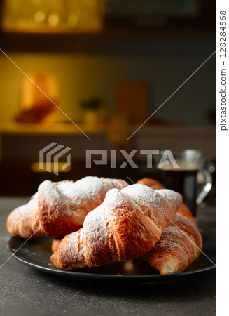 Croissants sprinkled with sugar powder. 128284568