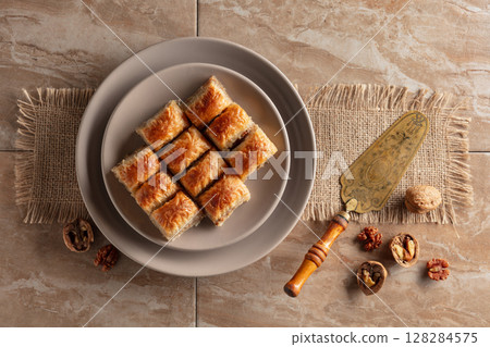 Baklava with walnuts on a beige plate. 128284575