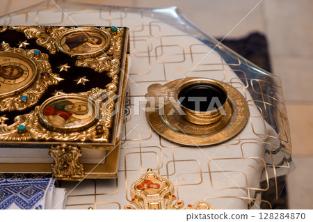 Orthodox Religious Artifacts Still Life: Vintage Book, Candleholder, and Incense Burner on White Fabric Background, Golden Tones Orthodox Religious Artifacts Still Life: Vintage Book, Candleholder, and Incense Burner on White Fabric Background, Golden Tones 128284870