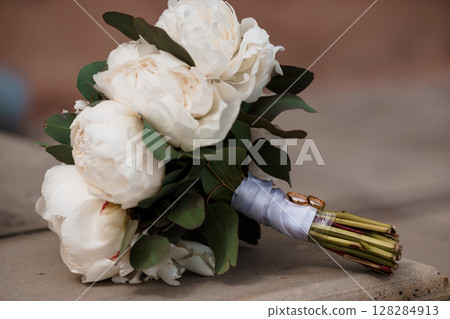 Romantic White Peony Wedding Bouquet with Blue-Gray Ribbon Close-Up, Natural Florals, Rustic Event Style, Wedding Details, Soft Lighting, Elegant Design. 128284913