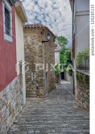 Narrow cobblestone street in historic mediterranean hilltop town Motovun, Croatia. Narrow cobblestone street in historic mediterranean hilltop town Motovun, Croatia. 128285133