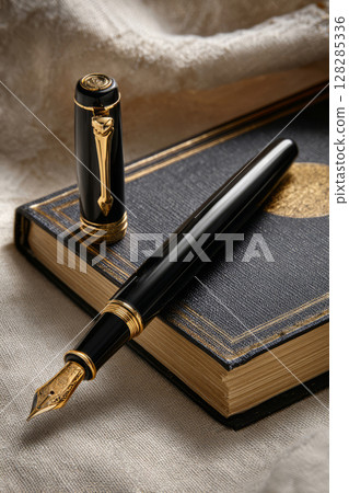Fountain pen with gold embellishments placed on vintage notebook 128285336