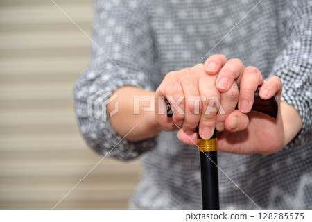 拄著拐杖行走並休息的老人圖片 128285575