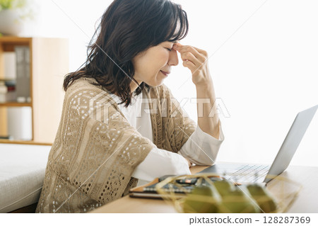 A middle-aged woman in her 50s suffering from eye fatigue A middle-aged woman in her 50s suffering from eye fatigue 128287369