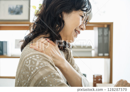 A middle-aged woman in her 50s suffering from stiff shoulders A middle-aged woman in her 50s suffering from stiff shoulders 128287370