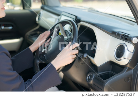 女人的手握著汽車的方向盤 128287527