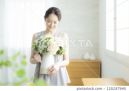 A woman holding a vase 128287940