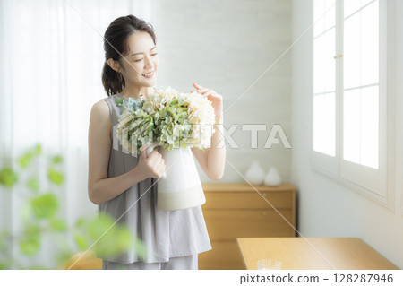 A woman holding a vase 128287946