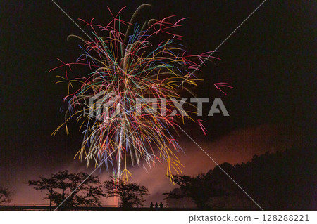 Fireworks lighting up the mountain night sky Fireworks lighting up the mountain night sky 128288221