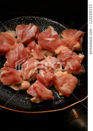 多汁的雞腿放入平底鍋中煎炸 多汁的雞腿放入平底鍋中煎炸 128288315