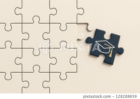 Missing puzzle piece with graduation cap completes a nearly finished puzzle 128288659
