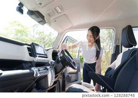Woman cleaning the car Woman cleaning the car 128288748