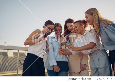 A Group of Close Friends Enjoying Their Time Together on a Beautiful Rooftop Space 128289307