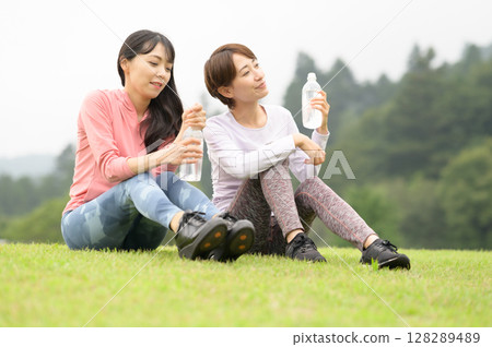 Two women rehydrating after exercise 128289489