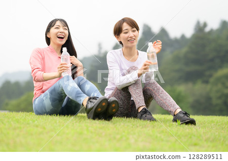 Two women rehydrating after exercise Two women rehydrating after exercise 128289511