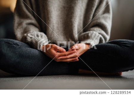 Close up of a woman hands in a lotus pose meditating on a bed at home 128289534