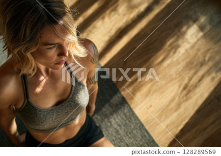 Young woman doing yoga stretches in the living room at home Young woman doing yoga stretches in the living room at home 128289569