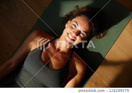 Young woman doing yoga stretches in the living room at home 128289579