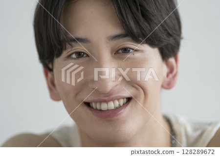 一名 20 多歲的男子對著鏡頭微笑 男士美人像肖像 128289672