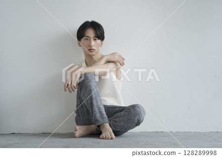 A man in his 20s sitting looking at the camera Men's beauty image Portrait 128289998