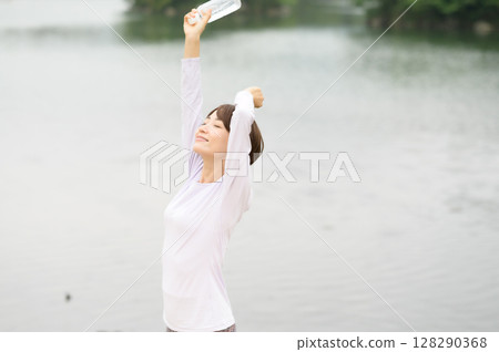 Woman holding a plastic bottle in the park 128290368
