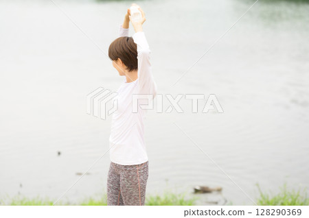 Woman holding a plastic bottle in the park 128290369