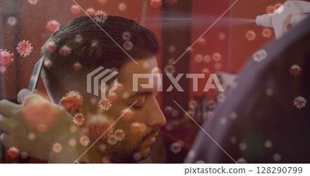Man getting haircut while barber sprays disinfectant, virus particles overlay 128290799