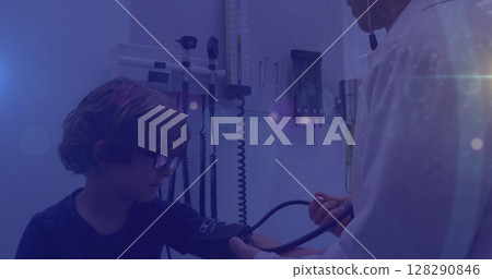 Image of bright streaks of light over a boy and male doctor at the hospital 128290846