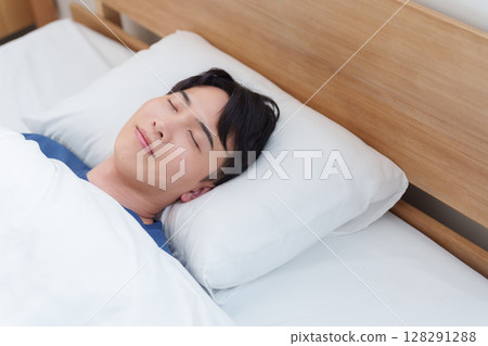 Man sleeping in bed in the morning Man sleeping in bed in the morning 128291288