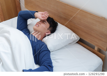 A man with a fever sleeping in bed A man with a fever sleeping in bed 128291290
